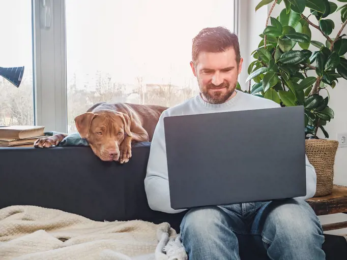 Man on laptop with his dog