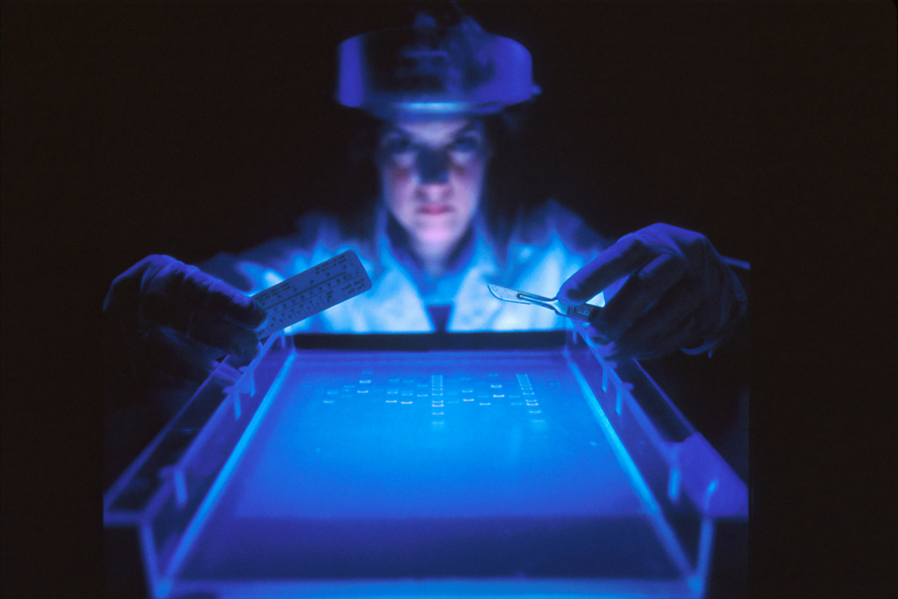 A scientist working in a dark laboratory to profile DNA