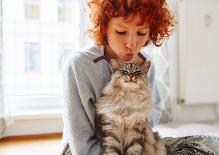 woman kissing a cat's head