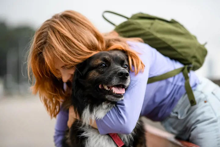 woman with ginger dog hugging a rescue dog