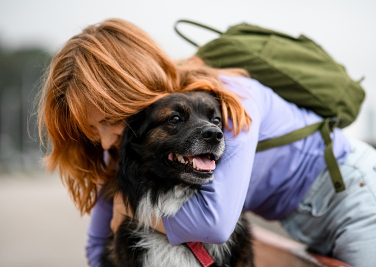 woman with ginger dog hugging a rescue dog