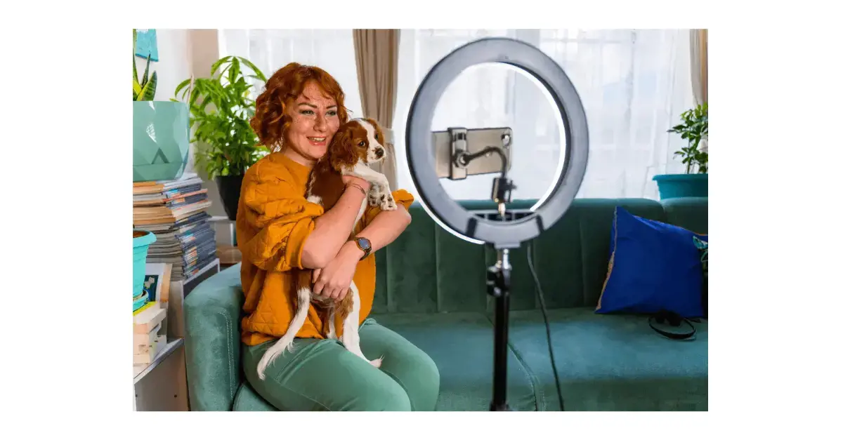Woman holding her dog in front of camera for social media