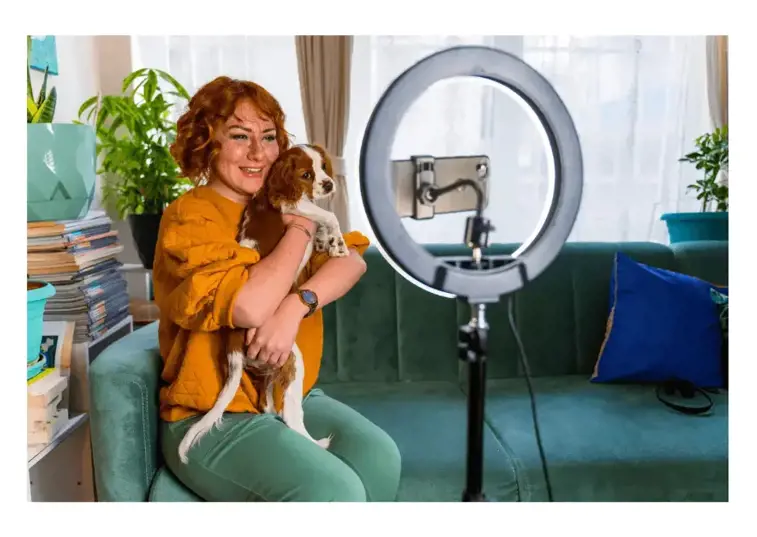 Woman holding her dog in front of camera for social media